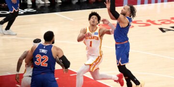 Knicks guard Jalen Brunson (11) goes up for a shot as Atlanta Hawks forward Jalen Johnson (1) gives chase during the fourth quarter.