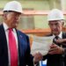 President Donald Trump and Federal Reserve Chairman Jerome Powell wearing hard hats and looking at a document.