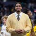 Indiana Pacers guard Tyrese Haliburton smiling while wearing a yellow cardigan, white collared shirt, and patterned tie.