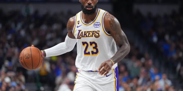 LeBron James dribbles the basketball while wearing a white Lakers jersey with "23" on it.