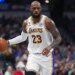 LeBron James dribbles the basketball while wearing a white Lakers jersey with "23" on it.