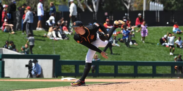 A baseball pitcher in a black and orange uniform mid-delivery.