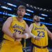 Two Lakers fans, Tom Biddle and Mantis Taylor, wearing Luka Doncic and Lebron James jerseys respectively, cheer from the stands.