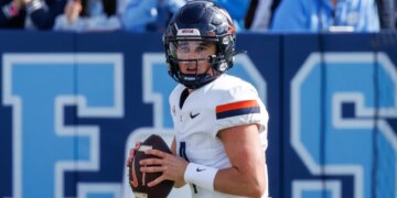 Chandler Morris wearing a white Virginia football jersey and black helmet, holding a football.