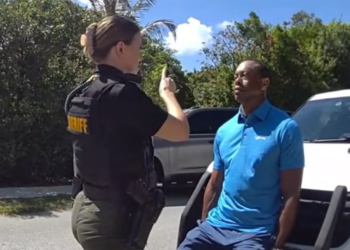 A female officer instructing a man in a blue shirt.
