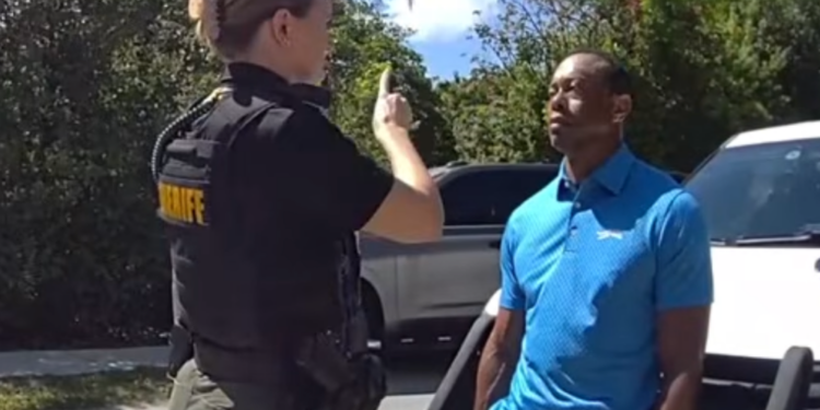 A female officer instructing a man in a blue shirt.