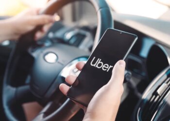 Uber driver holding a smartphone in a car.
