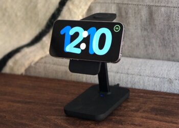 A photo of an iPhone in StandBy mode on a wood desk.