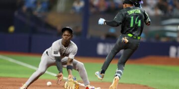 Rays left fielder Chandler Simpson (14) runs out a single past Yankees second baseman Jazz Chisholm Jr. (13) in the tenth inning on April 11, 2026.