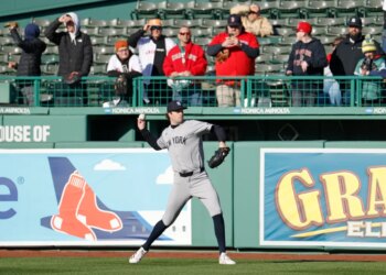 New York Yankees pitcher Cam Schlittler warms up on the field during batting practice.
