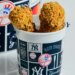 Two pieces of fried chicken in a New York Yankees branded cup.