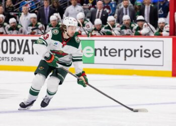 Quinn Hughes of the Minnesota Wild skates with the puck during a hockey game.