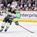 Quinn Hughes of the Minnesota Wild skates with the puck during a hockey game.
