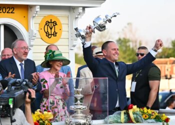 Chad C. Brown, trainer of horse Early Voting, holds the Woodland Vase after his horse won the 147th running of the Preakness Stakes.