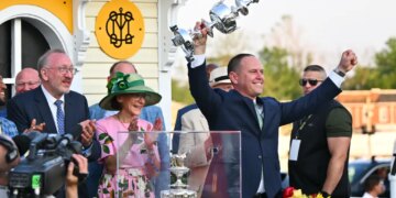 Chad C. Brown, trainer of horse Early Voting, holds the Woodland Vase after his horse won the 147th running of the Preakness Stakes.