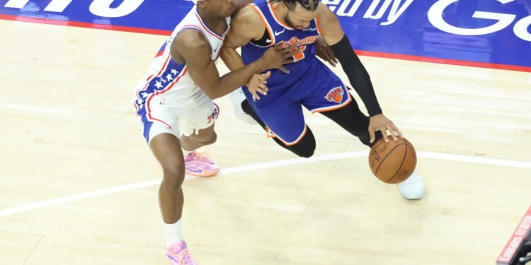 New York Knicks guard Jalen Brunson #11 drives to the basket as Philadelphia 76ers guard Vj Edgecombe #77 gives chase.