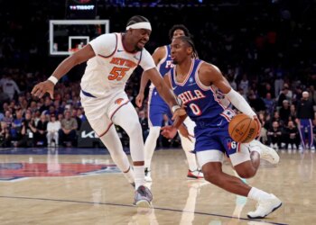 Philadelphia 76ers guard Tyrese Maxey #0 drives to the basket as New York Knicks center Ariel Hukporti #55 gives chase in the second quarter.