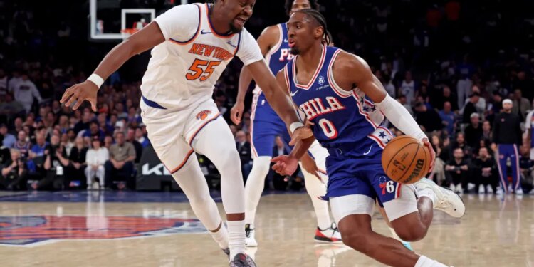 Philadelphia 76ers guard Tyrese Maxey #0 drives to the basket as New York Knicks center Ariel Hukporti #55 gives chase in the second quarter.
