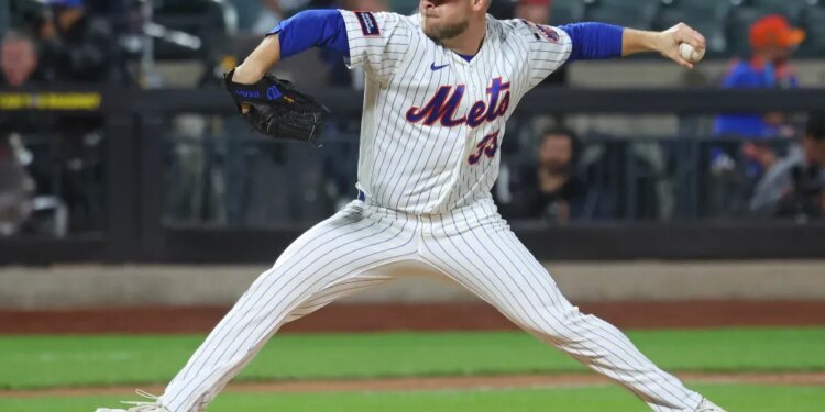 New York Mets pitcher throwing a baseball during a game against the Cincinnati Reds.