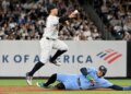 Yankees shortstop Anthony Volpe jumps over Blue Jays designated hitter George Springer during a double play.
