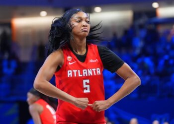 Angel Reese of the Atlanta Dream flexes after scoring during a WNBA basketball game.