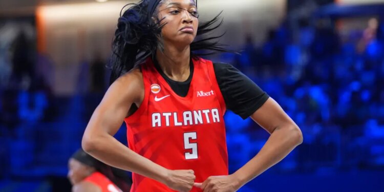 Angel Reese of the Atlanta Dream flexes after scoring during a WNBA basketball game.