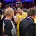 Austin Reaves talking with referee John Goble after a basketball game.