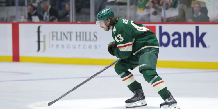 Quinn Hughes (43) of the Minnesota Wild skates on the ice during a game.