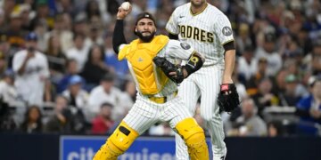San Diego Padres catcher Austin Nola throws to a base as pitcher Joe Musgrove watches.