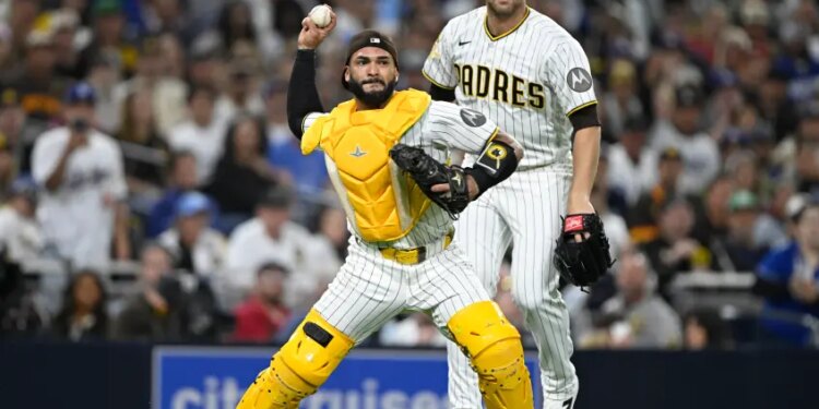 San Diego Padres catcher Austin Nola throws to a base as pitcher Joe Musgrove watches.