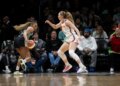 Betnijah Laney-Hamilton dribbles the basketball while being guarded by Gianna Kneepkens during a game.