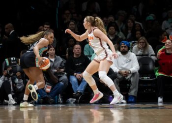 Betnijah Laney-Hamilton dribbles the basketball while being guarded by Gianna Kneepkens during a game.