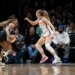 Betnijah Laney-Hamilton dribbles the basketball while being guarded by Gianna Kneepkens during a game.