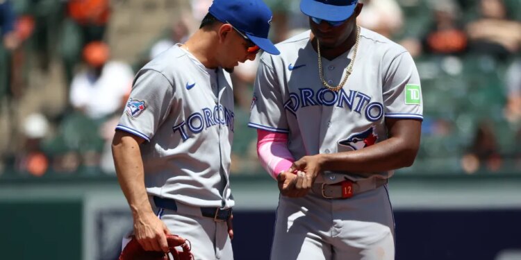 Toronto Blue Jays players Jesus Sanchez and Andres Gimenez speak on the field.