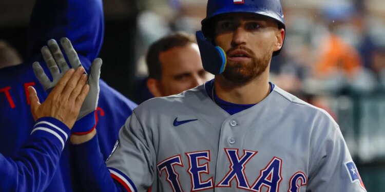 Texas Rangers right fielder Brandon Nimmo (24) receives congratulations from teammates after scoring 3i against the Detroit Tigers at Comerica Park.