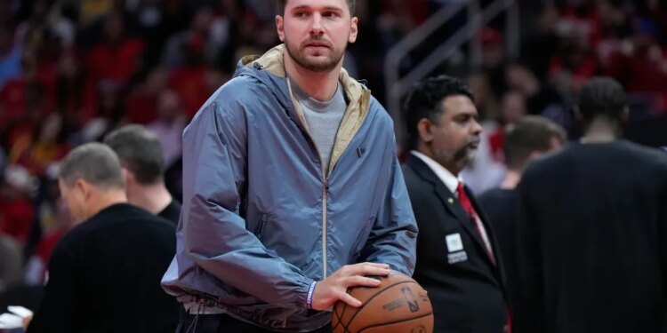 Luka Doncic holds a basketball during a timeout.