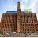 Domino Sugar Refinery building with a tall brick chimney and "Domino Sugar" sign on top.