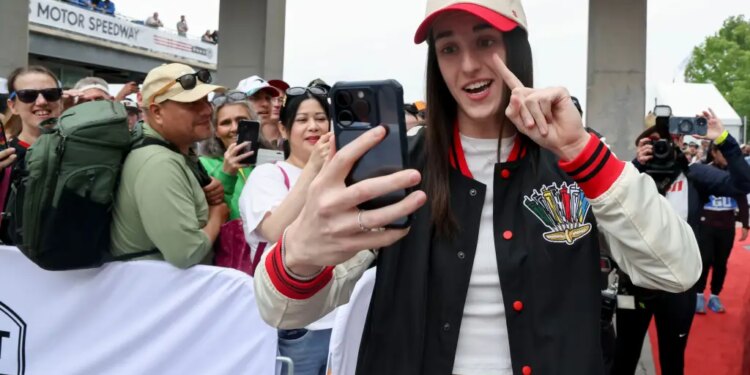 Indiana Fever guard Caitlin Clark takes a selfie with fans at the 110th Running of the Indianapolis 500.