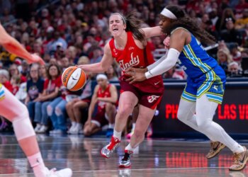 Caitlin Clark (22) reacting to contact from Arike Ogunbowale (24) during a WNBA game.