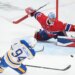Buffalo Sabres' Konsta Helenius (94) shoots and scores against Montreal Canadiens goaltender Jakub Dobes (75) as Canadiens' Arber Xhekaj, left, defends during the second period of Game 6 in a second-round NHL hockey Stanley Cup playoff series in Montreal, Saturday, May 16, 2026. (Graham Hughes/The Canadian Press via AP)