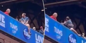Cardinals fan dangerously hangs off upper deck ledge in terrifying scene