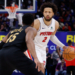 Detroit Pistons guard Cade Cunningham dribbles past Cleveland Cavaliers guard Donovan Mitchell during a game.