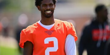 Shedeur Sanders smiling in an orange jersey with number 2.