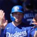 Dalton Rushing in his blue Dodgers uniform and batting helmet high-fives teammates in the dugout.