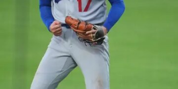 Shohei Ohtani in a Dodgers uniform clenching his fist and yelling.