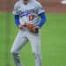Shohei Ohtani in a Dodgers uniform clenching his fist and yelling.