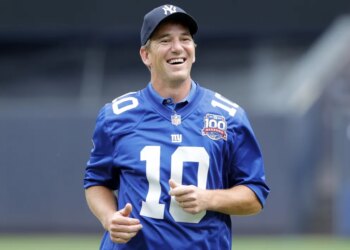 Eli Manning is all smiles after throwing out a ceremonial first pitch during a Yankees game in 2024.