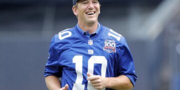 Eli Manning is all smiles after throwing out a ceremonial first pitch during a Yankees game in 2024.