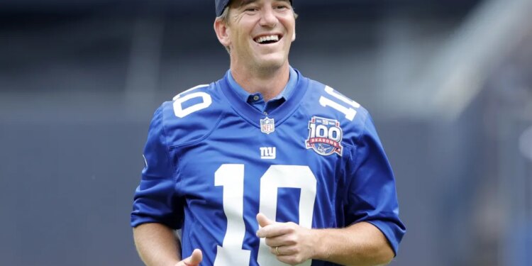Eli Manning is all smiles after throwing out a ceremonial first pitch during a Yankees game in 2024.