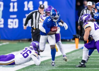 New York Giants player Deonte Banks runs the ball as Minnesota Vikings player Ivan Pace Jr. tackles him.